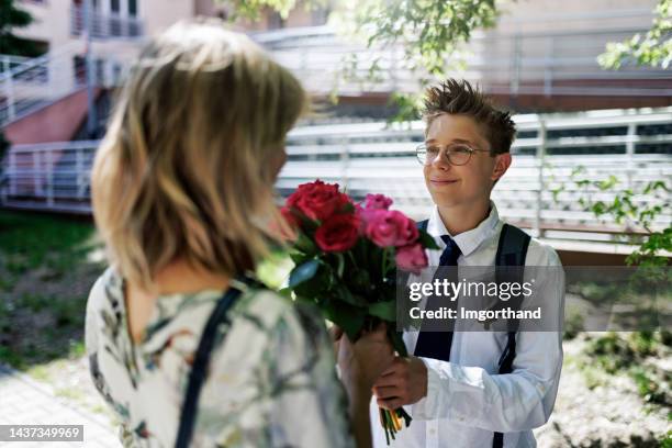 teenage son giving flowers to his mother - twelve roses stock pictures, royalty-free photos & images