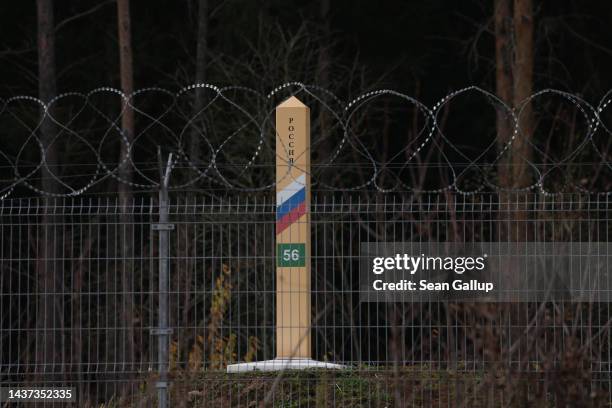 Russian border marker stands behind barbed wire on the border between the Russian semi-exclave of Kaliningrad and Lithuania on October 28, 2022 near...