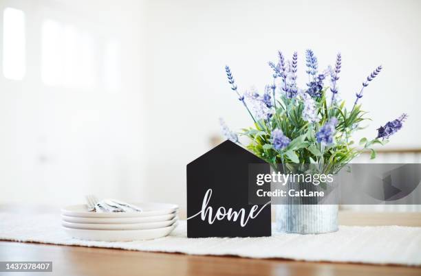 dining room table with home sign and lavender plant in a bright modern home setting. shot with space for copy - home sweet home stockfoto's en -beelden