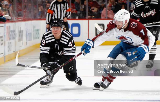 Fabian Zetterlund of the New Jersey Devils and Devon Toews of the Colorado Avalanche battle for the puck during the second period at the Prudential...