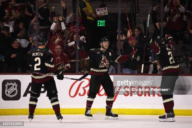 Christian Fischer of the Arizona Coyotes celebrates with Jack McBain and Patrik Nemeth after Fischer scored a goal against the Winnipeg Jets during...