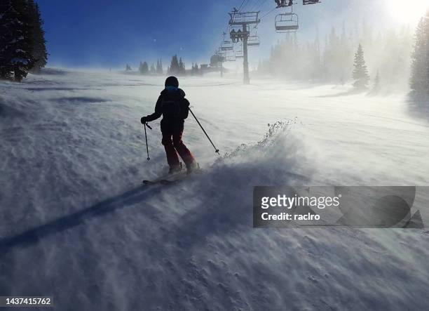 mature woman skier in silhouette with gale force wind behind. snowmass ski resort aspen, colorado. - snowmass stock pictures, royalty-free photos & images
