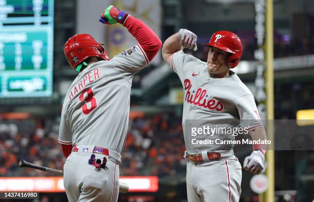 Bryce Harper and J.T. Realmuto of the Philadelphia Phillies celebrate after Realmuto hit a home run in the 10th inning against the Houston Astros in...