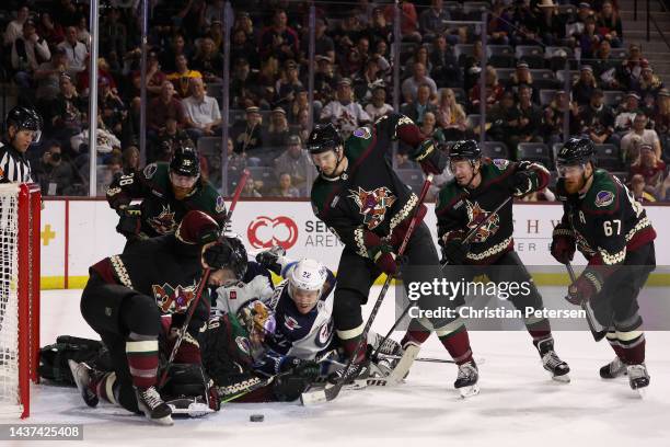 Goaltender Karel Vejmelka, Liam O'Brien and Josh Brown of the Arizona Coyotes attempt to clear the puck as Mason Appleton of the Winnipeg Jets...