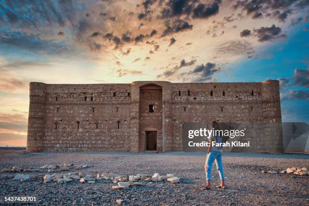 tourist within the grounds of qasr kharana in jordan. - qasr kharana stockfoto's en -beelden