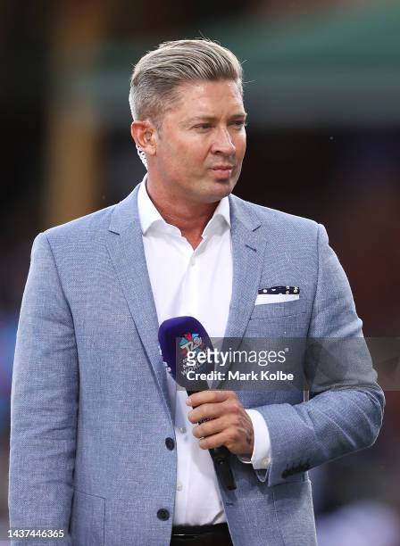 Former Australian cricketer Michael Clarke watches on as he waits to speak on camera before the ICC Men's T20 World Cup match between New Zealand and...