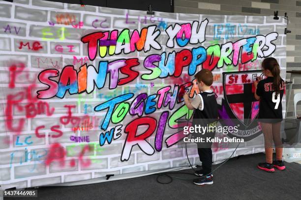 Fans paint a banner during the round 10 AFLW match between the St Kilda Saints and the Adelaide Crows at RSEA Park on October 29, 2022 in Melbourne,...