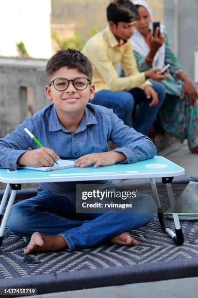 elementary age student doing homework at home - charpoy stock pictures, royalty-free photos & images