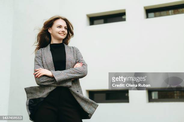young woman looking in the distance with crossed arms. - chaqueta a cuadros fotografías e imágenes de stock