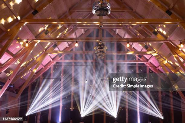 powerful moving light beams on the ceiling structure in the interior of a public event, fashion show, concert or wedding reception. - wedding lights stock pictures, royalty-free photos & images