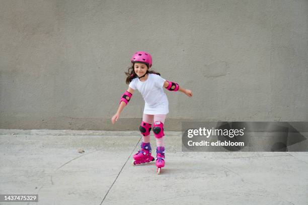 cute little girl riding in roller skates - kneepad stock pictures, royalty-free photos & images