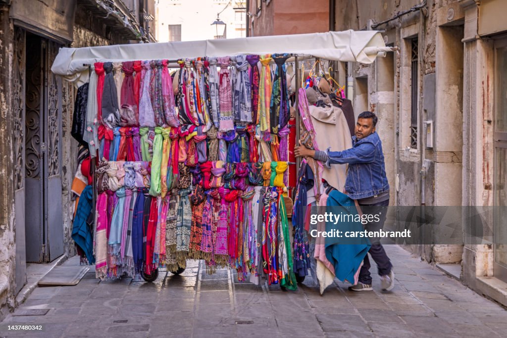Person Pushing Garment Rack Man Pulling A Rack With Garment Cross The Street High-Res Stock Photo ...