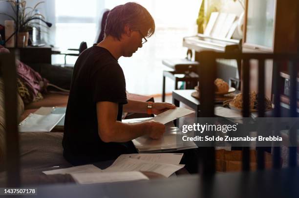 middle-aged man working from home sitting on the sofa - disheveled man imagens e fotografias de stock