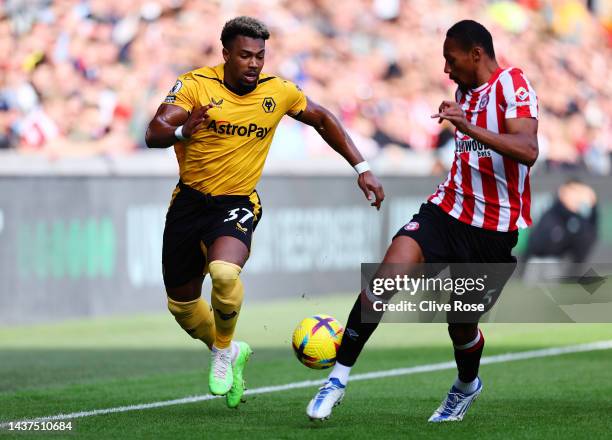 Adama Traore of Wolverhampton Wanderers is challenged by Ethan Pinnock of Brentford during the Premier League match between Brentford FC and...