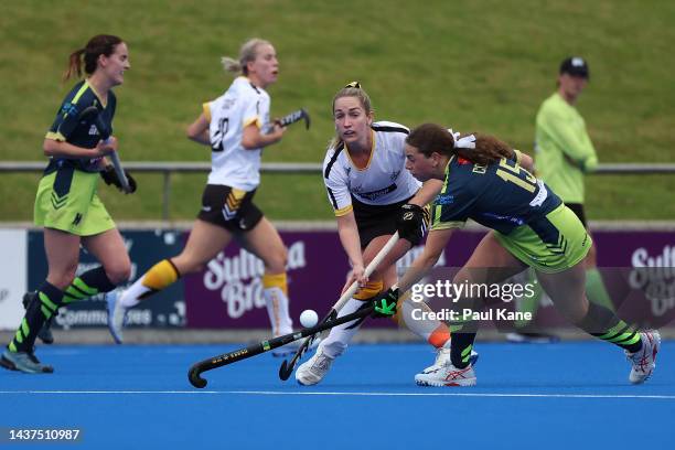 Kyra White of the Thundersticks passes the ball against Lucy Cooper of the Tigers during the round five Hockey One League match between Perth...