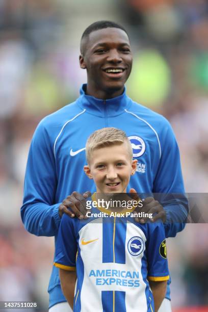 Moises Caicedo of Brighton & Hove Albion lines up with a mascot prior to the Premier League match between Brighton & Hove Albion and Chelsea FC at...