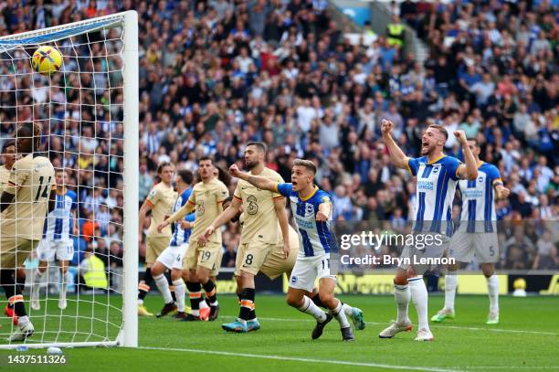 Leandro Trossard and Adam Webster of Brighton & Hove Albion celebrate after Ruben Loftus-Cheek of Chelsea scored an own goal which leads to Brighton...