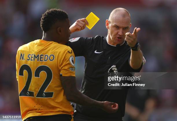 Nelson Semedo of Wolverhampton Wanderers receives a yellow card from Referee Robert Madley during the Premier League match between Brentford FC and...