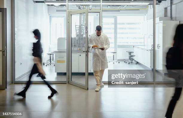 scientist exiting the laboratory - scientist walking away stock pictures, royalty-free photos & images