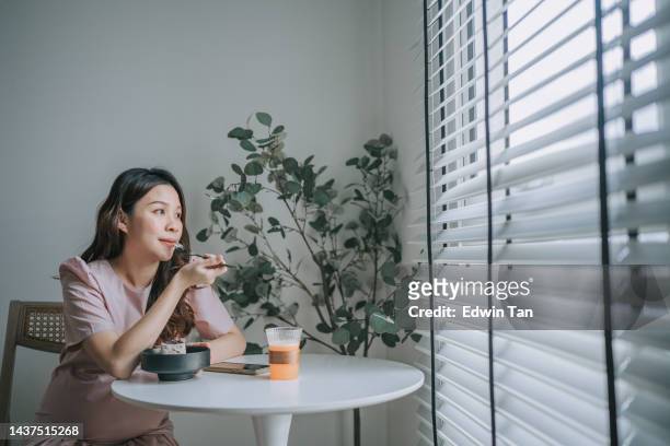 mujer embarazada china asiática disfrutando de su postre en el café sola soñando despierta - woman day dreaming fotografías e imágenes de stock