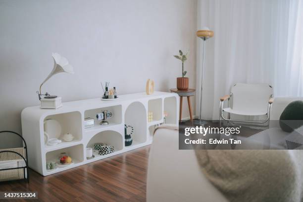 living room with shelf, sofa. cushion, houseplant  beside window - simple living room stock pictures, royalty-free photos & images