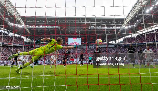 Christopher Nkunku of RB Leipzig scores their team's first goal past Lukas Hradecky of Bayer 04 Leverkusen during the Bundesliga match between RB...