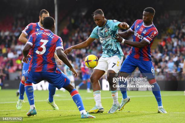 Joe Aribo of Southampton is challenged by Marc Guehi and Tyrick Mitchell of Crystal Palace during the Premier League match between Crystal Palace and...