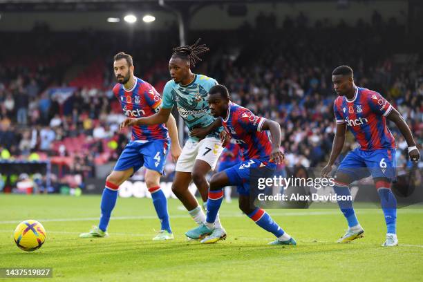 Joe Aribo of Southampton is challenged by Luka Milivojevc, Marc Guehi, and Tyrick Mitchell of Crystal Palace during the Premier League match between...
