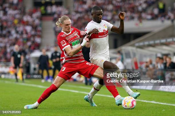 Sehrou Guirassy of VfB Stuttgart is challenged by Fredrik Jensen of Augsburg during the Bundesliga match between VfB Stuttgart and FC Augsburg at...
