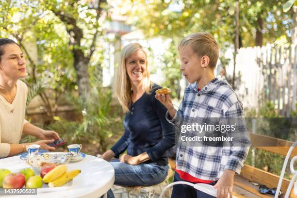 boy eating a cookie - tia imagens e fotografias de stock