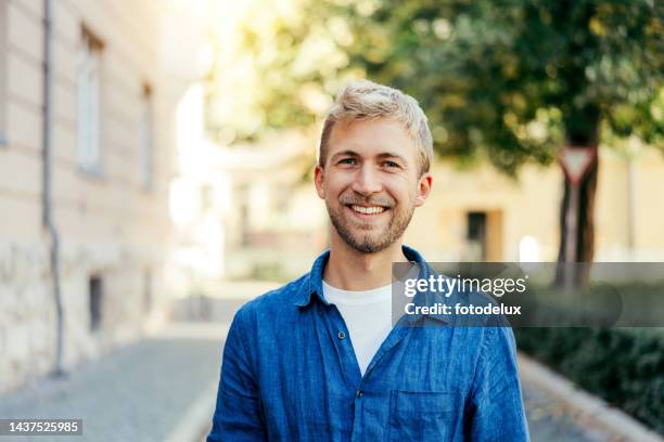 portrait of a handsome young man standing outside is house - one young man only stock pictures, royalty-free photos & images