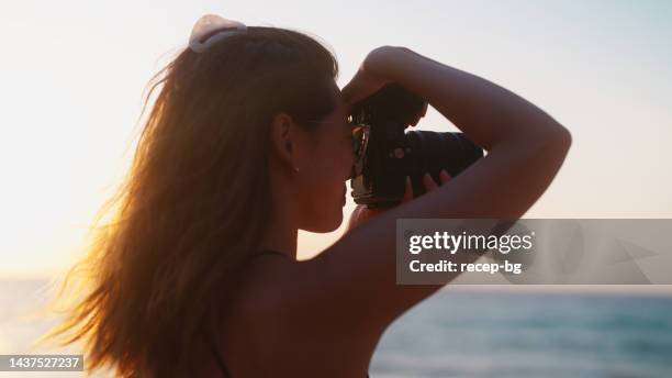young female tourist taking photos and videos by the sea - photographer seascape stock pictures, royalty-free photos & images