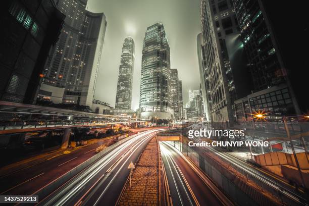 traffic trails in financial district, hong kong - vehicle light stock pictures, royalty-free photos & images