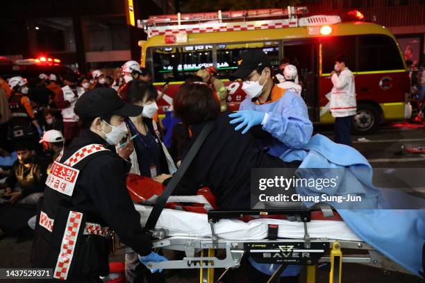 Emergency services carry injured people after a stampede on October 30, 2022 in Seoul, South Korea. At least 50 people were reported to be receiving...