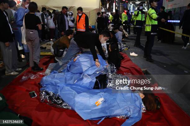 Emergency services treat injured people after a stampede on October 30, 2022 in Seoul, South Korea. At least 50 people were reported to be receiving...