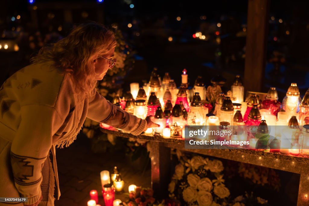 A woman came to light a candle at the cemetery in memory of the deceased.