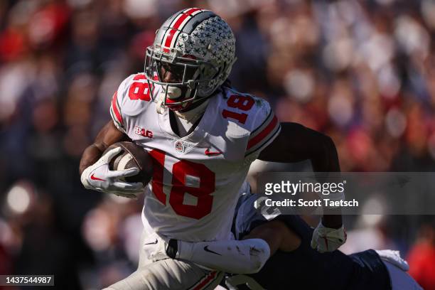 Marvin Harrison Jr. #18 of the Ohio State Buckeyes carries the ball against Keaton Ellis of the Penn State Nittany Lions during the first half at...