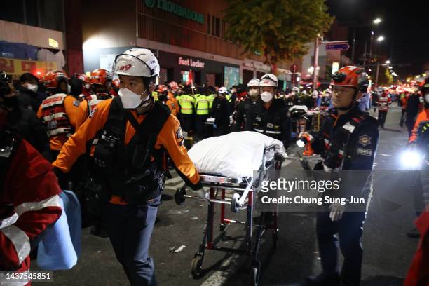 Emergency services transport a person after a stampede during a Halloween celebration October 30, 2022 in Seoul, South Korea. Fifty-nine people have...