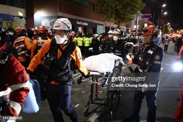 Emergency services transport a person after a stampede during a Halloween celebration October 30, 2022 in Seoul, South Korea. Fifty-nine people have...