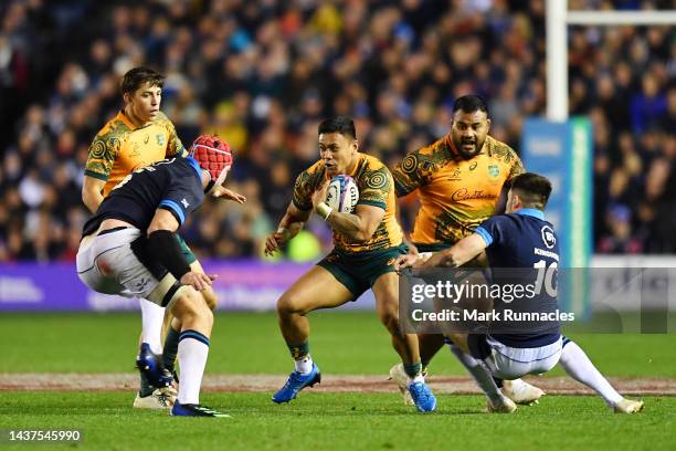 Len Ikitau of Australia is challenged by Grant Gilchrist and Blair Kinghorn of Scotland during the Autumn International match between Scotland and...
