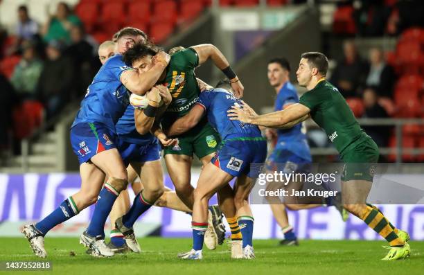 Tino Fa'asuamaleaui of Australia is tackled by Nathan Brown of Italy during Rugby League World Cup 2021 Pool B match between Australia and Italy at...