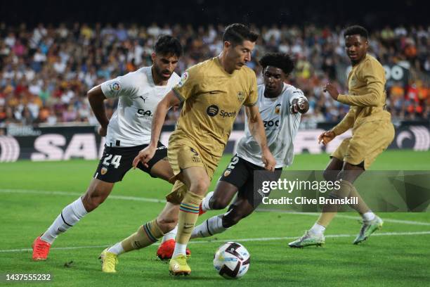 Robert Lewandowski of FC Barcelona is put under pressure by Eray Comert and Thierry Correia of Valencia CF during the LaLiga Santander match between...