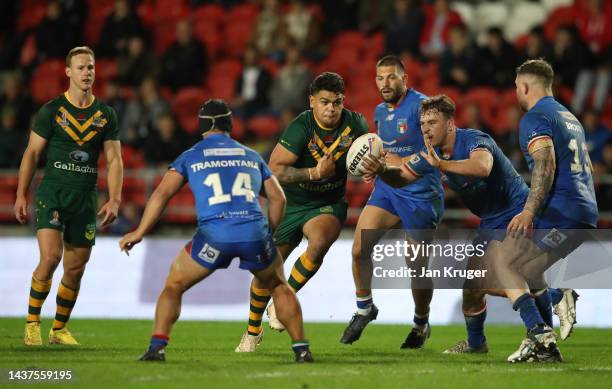 Latrell Mitchell of Australia looks to break past Joel Tramontana and Nathan Brown of Italy during Rugby League World Cup 2021 Pool B match between...