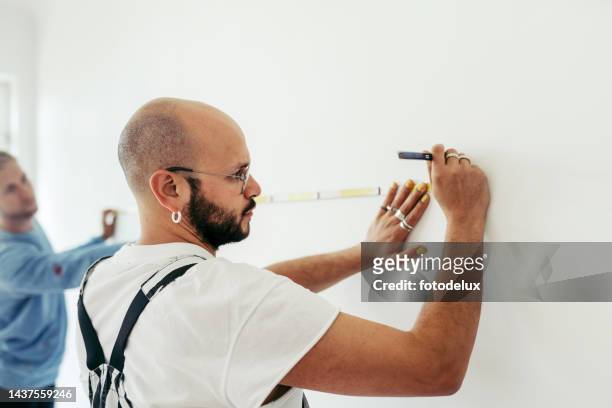 two male friends taking measurements using a measuring tape - length stock pictures, royalty-free photos & images