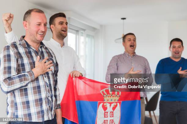 close-up of men singing national anthem indoors - serbian flag stock pictures, royalty-free photos & images