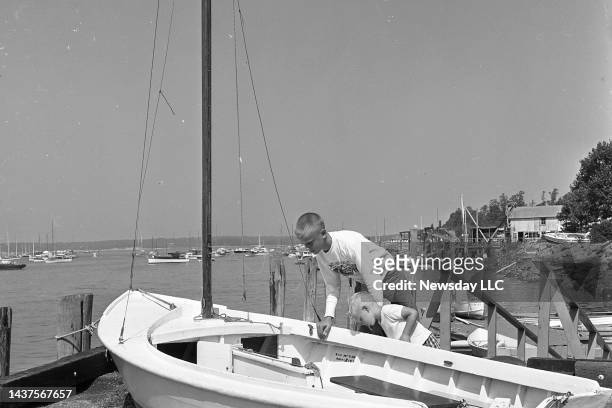 Stephen Jordan and David Jordan of Greenlawn, New York, look at a sailboat which was deposited on top of Northport Dock when water from Hurricane...