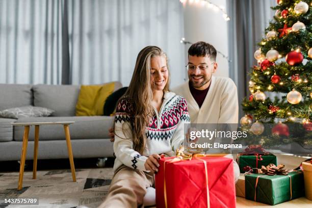 man giving a christmas present to his girlfriend at home - real wife sharing 個照片及圖片檔