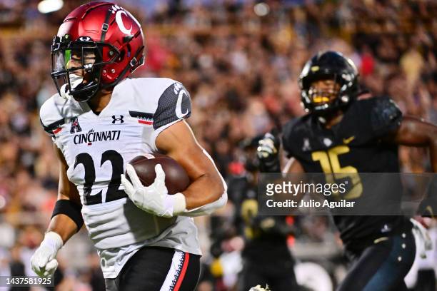 Ryan Montgomery of the Cincinnati Bearcats runs past Jason Johnson of the UCF Knights for a 39-yard touchdown in the fourth quarter of the game at...
