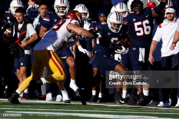 Running back Michael Wiley of the Arizona Wildcats stiff arms defensive lineman Nick Figueroa of the USC Trojans during the first half of the game at...