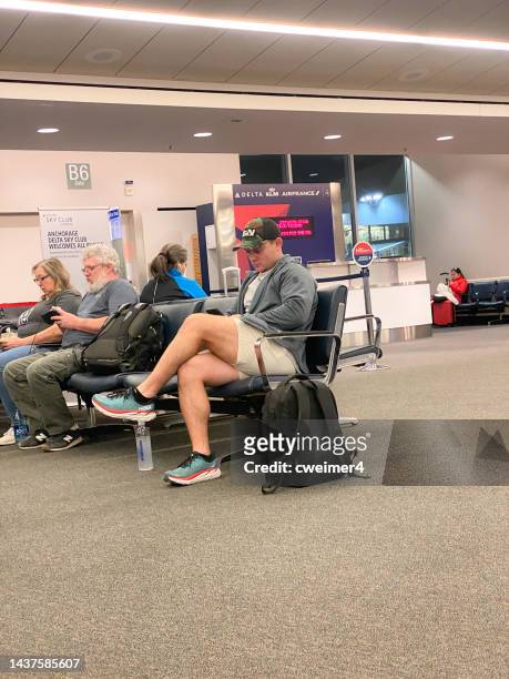 on cell phone, waiting to fly - anchorage airport stockfoto's en -beelden